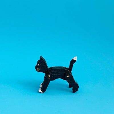 Wooden cat ornament on a blue background. 