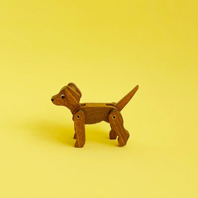 Wooden dog figurine on a yellow background. 
