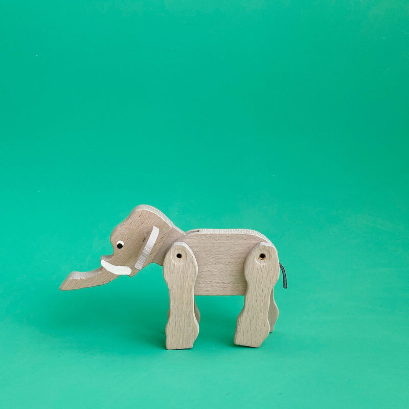 Wooden elephant figurine on a green background.
