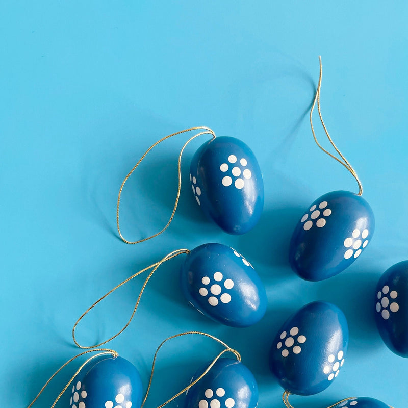 Several blue egg shaped ornaments  on a blue background. 