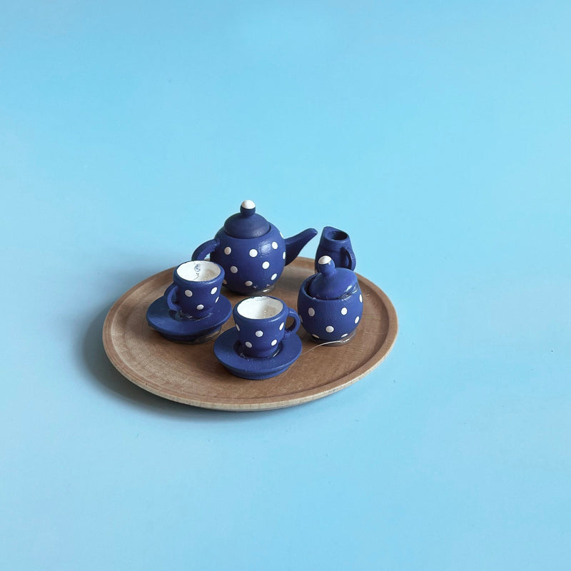 Blue and white wooden mini  tea set on a light blue background
